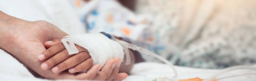 Patient holding a parent's hand.