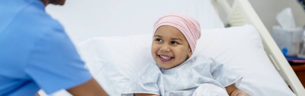 Child with cancer in a hospital looking at a medical professional.