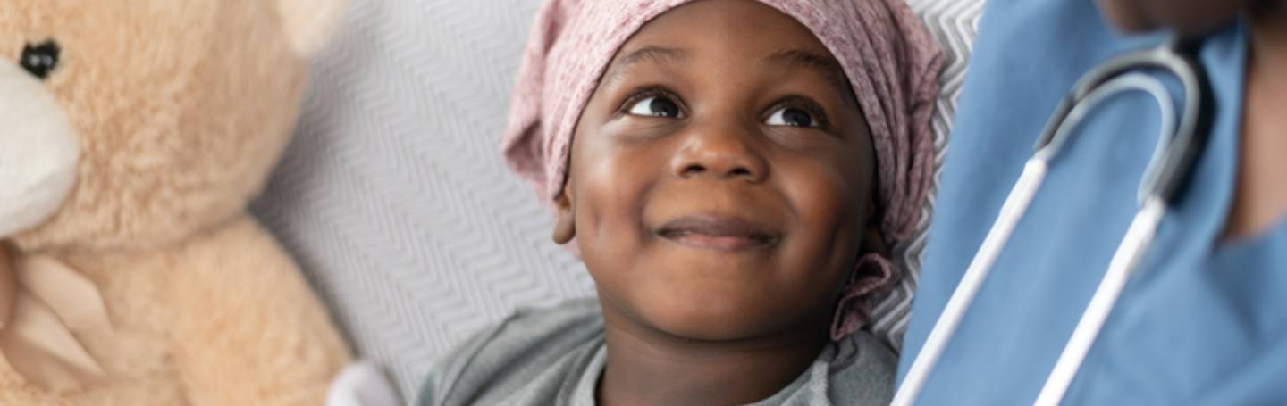 Child with cancer looking up at a Doctor.